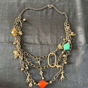 Charm necklace with red and blue beads, animals in matte gold and gold chain.